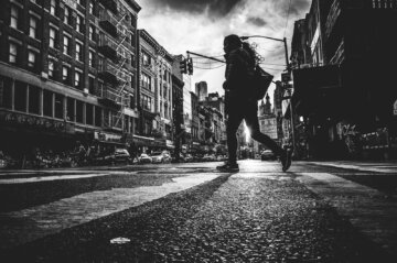 A woman silhouette walks across East Braodway Street in New York City